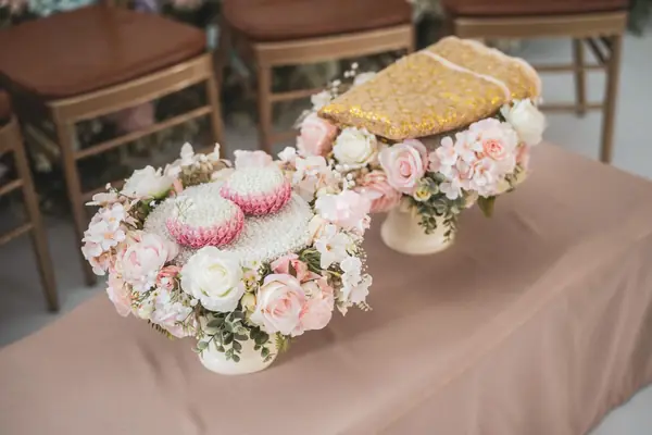 Rosa Blumengestecke und ein goldenes Kissen auf einem Tisch, Dekoration einer Trauung